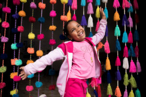 Josefina plays among the pompoms at a child-friendly space for Venezuelan migrants in Lima, Peru.