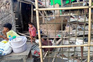 Two children in a destroyed home in Myanmar, after the impact of hurricane Mocha.