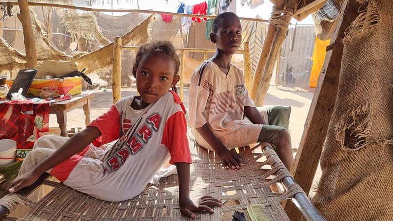 Moayad,12, with his sister Arig, 7, near their home in Khartoum, Sudan