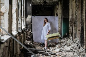 Olena*, 17, poses for a portrait at her damaged school outside of Kyiv (Oleksandr Khomenko/Save the Children)