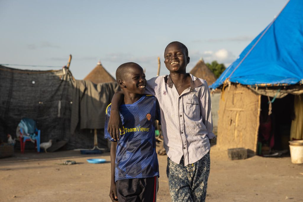 Jok, 12, and his best friend Kuol, 10, walking through their village in Akobo West, South Sudan.