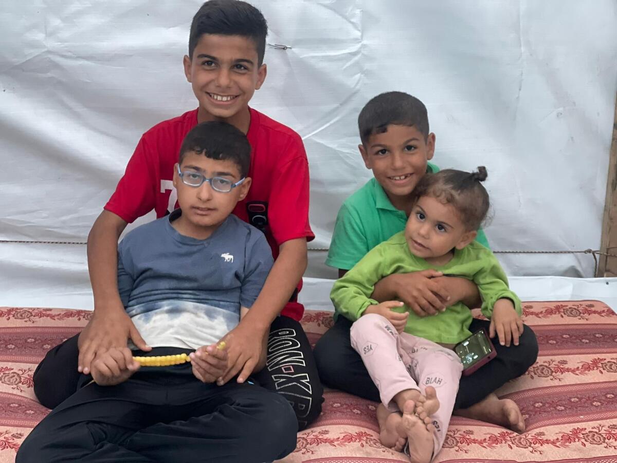 Twelve-year-old Hisham*, (in red t-shirt), sits with his siblings Basar* 10, Said*, 7 and Mariam*, 2 and a half.